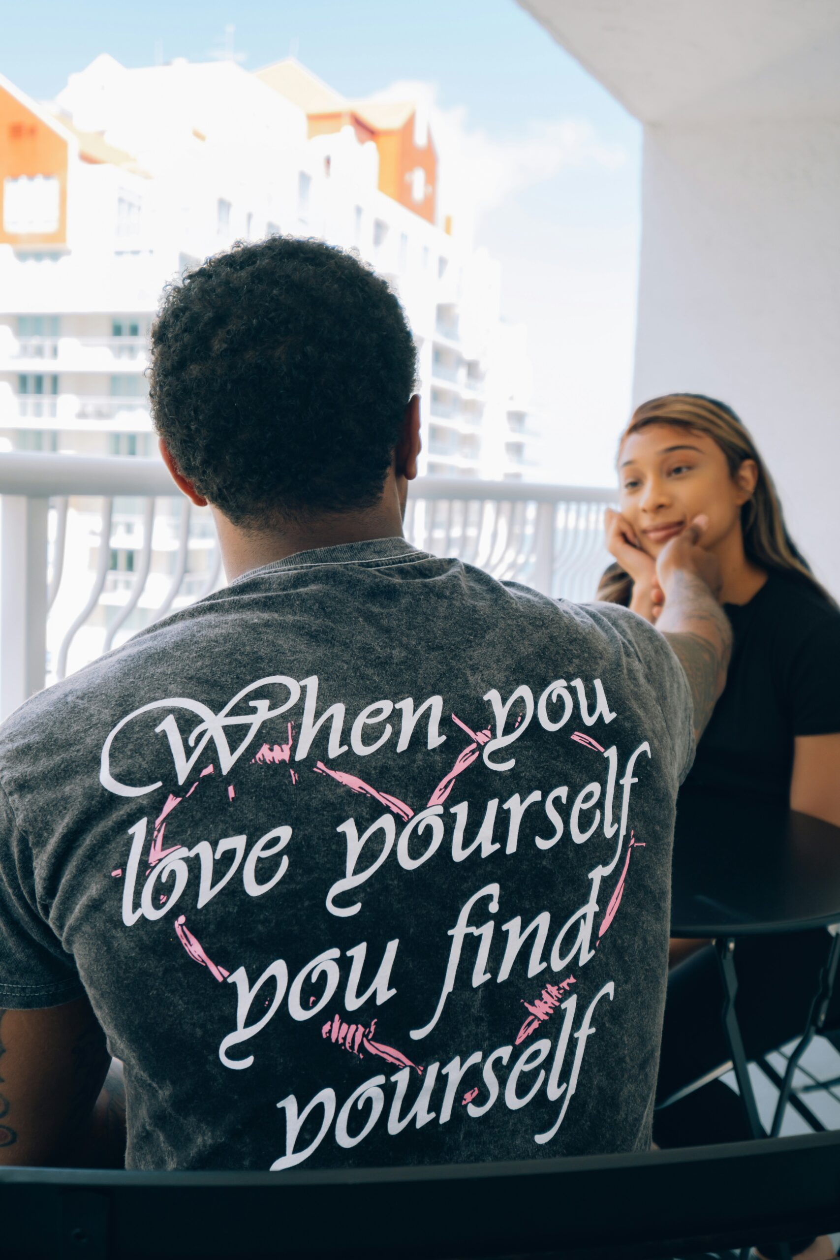 man in gray crew neck t-shirt sitting beside woman in black shirt